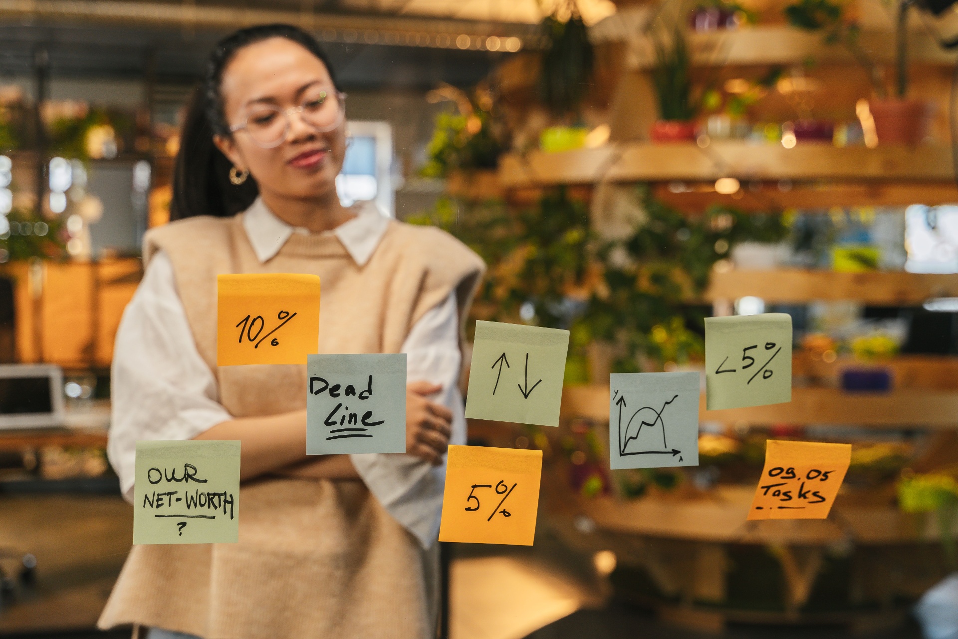 Strategist mapping deliverables and metrics on a glass wall